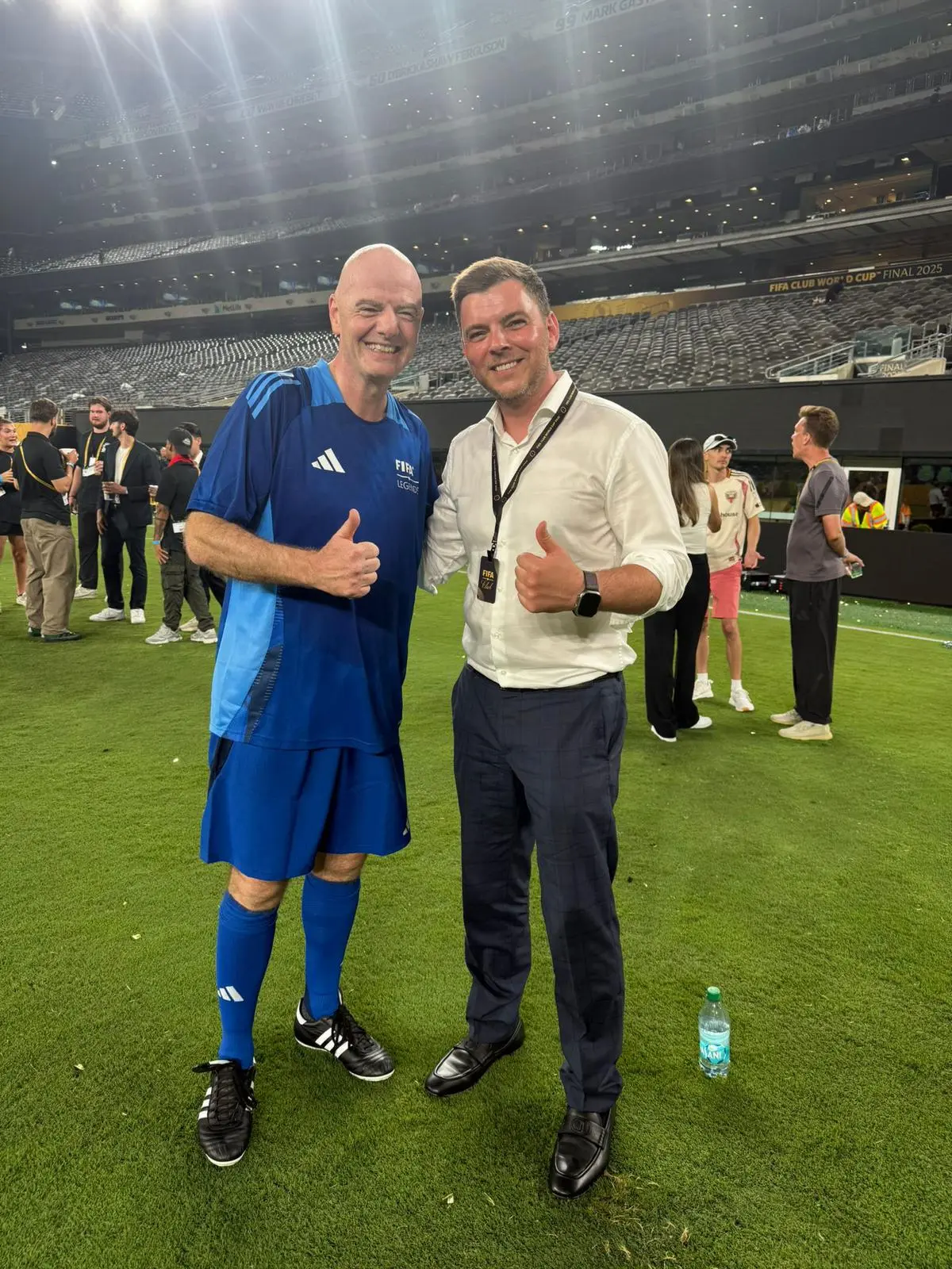 Filipp Sviridenko and FIFA President Gianni Infantino giving a thumbs-up on the pitch at MetLife Stadium