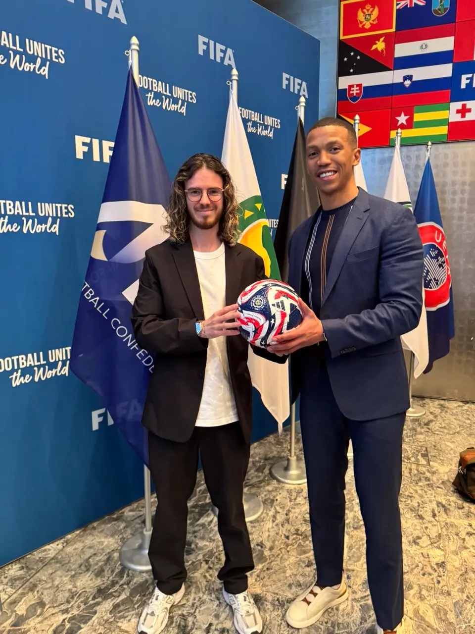 Marks Amosejevs and a club executive holding a football