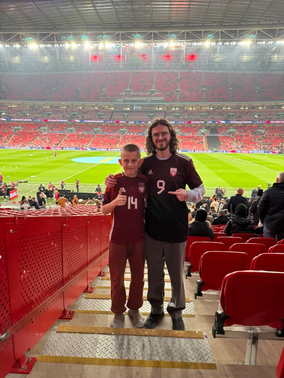 Marks Amosejevs and a young player, both in Latvia shirts, in the stand at Wembley Stadium